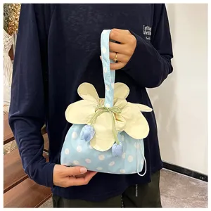 Dettaglio della borsa in tessuto a pois con petali di fiore e ciondoli a forma di tulipano.