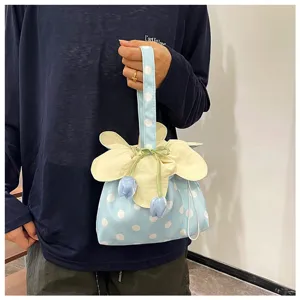 Primo piano dettagliato di una graziosa borsa in tessuto a pois con fiori e coulisse.