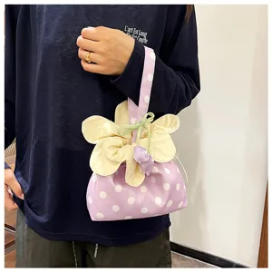 Primo piano della graziosa borsa a pois viola con fiori e ciondolo a tulipano e coulisse.