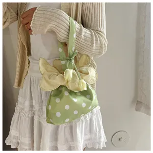 Primo piano di una borsa a pois verdi in stile coreano con decorazione floreale gialla.