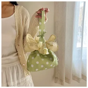 Dettaglio borsa a mano in tessuto a pois verdi stile coreano, simpatico design con coulisse floreale, borsa.