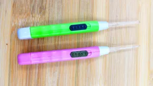 Detailed shot of luminous ear picks with built-in LED light in green and pink colors.