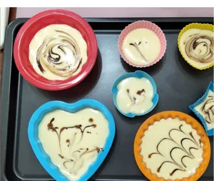 Ensemble de moules à gâteaux en silicone colorés, ronds et en cœur pour pâtisserie fine.