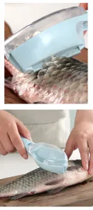 Nahansicht des praktischen Fischschuppen-Entferners in Verwendung auf einem Holzbrett.