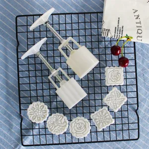 Handpresse Kuchenform Set mit austauschbaren Blumenstempeln für traditionelle Gebäckherstellung.