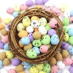 Oeufs de Pâques artificiels colorés et mouchetés avec nid en branches pour décoration de fête.