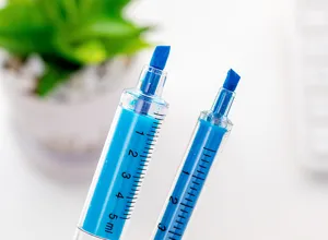 Close-up detail van de creatieve spuitvormige markeerstift met blauwe inkt en schaalverdeling.