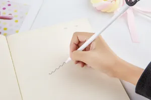Gros plan détaillé d'un joli stylo gel cartoon écrivant en douceur sur un carnet ligné.