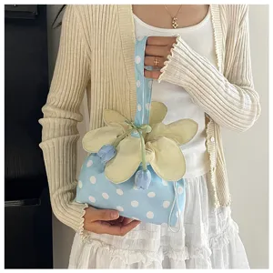Vista dettagliata della borsa in tessuto a pois azzurro con coulisse floreale e decoro a tulipano.