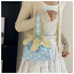 Primo piano della borsa in tessuto a pois, dettaglio con coulisse floreale, stile chic.