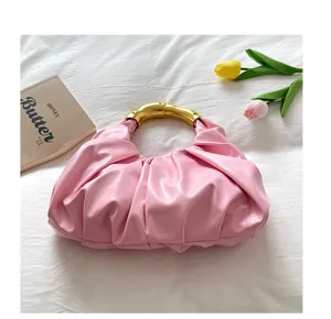 Schicke rosa plissierte Handtasche Detail, mit elegantem goldenem Metallgriff, stilvolles Design.