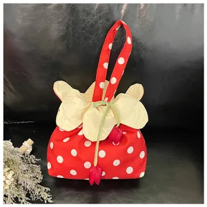 Bellissimo dettaglio di borsa in tessuto a pois rossi con coulisse floreale e tulipani.