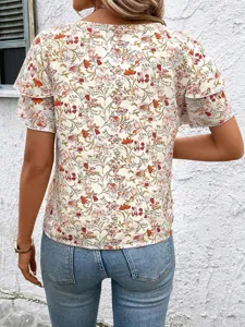 Detail view of women's short sleeve floral print blouse with ruffle details and round neck.