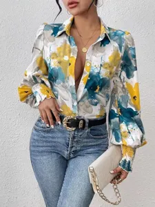 Detail shot of abstract floral print blouse with elegant puff sleeves and chic lapel collar.