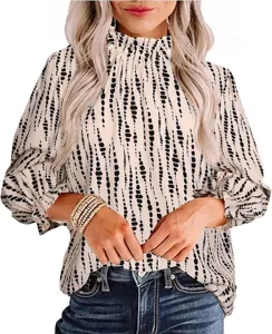 Detailed view of the elegant mock neck long sleeve blouse with black abstract dot print.