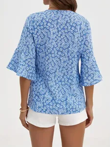 Vista posteriore della blusa floreale blu con elegante scollo a V e maniche a campana.