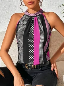 Close-up detail shot of a chic halter neck top featuring bold polka dots and striking vertical stripes.