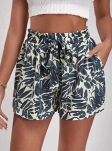 Detail view of women's high-waist casual shorts with tropical leaf print and tie belt.