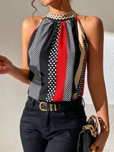 Close-up detail of the stylish halter neck top featuring bold polka dot and stripe print.
