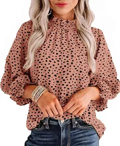 Close-up detail of women's long sleeve blouse with ruffled high neck and black polka dots.