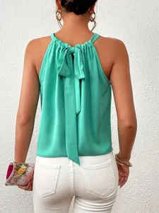 Women summer sleeveless halter neck tie back casual blouse in bright turquoise green color.