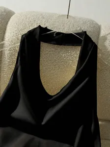Dettaglio top halter in raso nero, elegante design senza maniche drappeggiato chic.