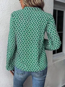 Detailed view of women's green printed long lantern sleeve blouse with chic pleated collar design.