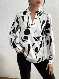 Detailed view of women's long sleeve V-neck blouse with chic black and white abstract print.