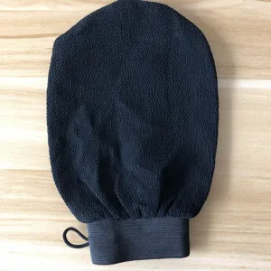 Vue détaillée du gant de gommage noir, tissu texturé rugueux pour le soin exfoliant du corps.