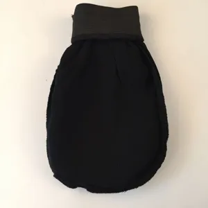 Vue détaillée du gant de gommage noir montrant sa texture rugueuse et son poignet élastique.