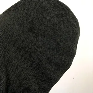 Gant de gommage marocain noir texture rugueuse pour le nettoyage en profondeur de la peau.