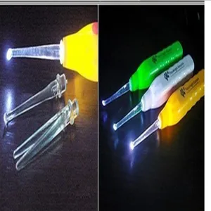 Close-up detail of the luminous ear spoon featuring interchangeable transparent tips and bright LED light.