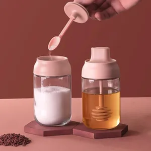 Primo piano di barattoli di vetro per condimenti da cucina con cucchiai integrati.