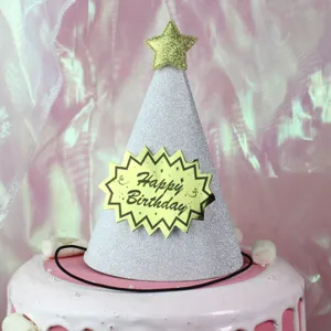 Sparkly silver birthday hat with gold star and party decorations for kids celebration.