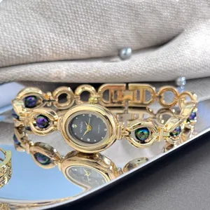 Dettaglio in primo piano dell'orologio al quarzo ovale elegante con perline colorate e cinturino.