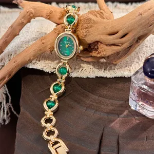 Primo piano dell'orologio al quarzo dorato con quadrante verde e cinturino su legno rustico.