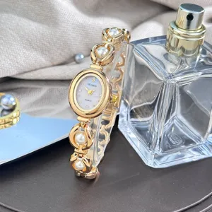 Elegante orologio da donna al quarzo con quadrante ovale e cinturino in metallo dorato.