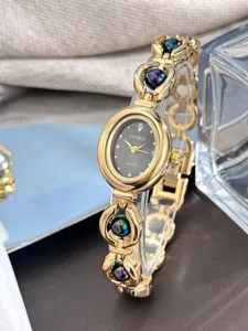 Primo piano del dettaglio di un orologio da donna al quarzo dorato con quadrante ovale e perle.
