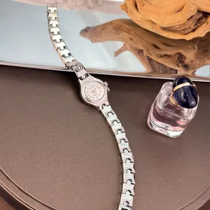 Exquisite minimalist small dial quartz watch with fine silver link strap for women stylish detail.
