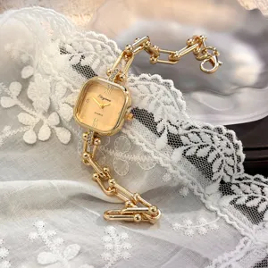 Primo piano dettagliato di un orologio al quarzo quadrato di lusso con cinturino a catena.