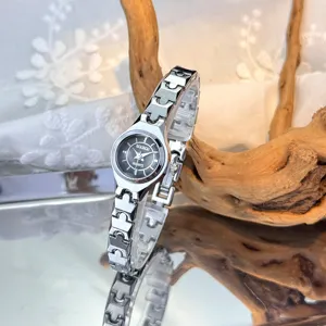 Elegant women's quartz watch with unique silver link band and small black dial.