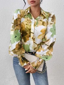 Close-up detail of women's long sleeve blouse featuring abstract print and puff sleeves.