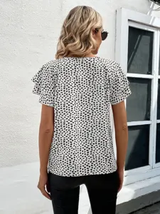 Back detail of women's short sleeve blouse with layered ruffles and abstract print design.