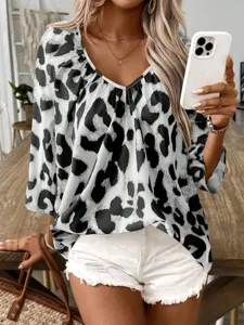 Detail view of stylish black and white leopard print V-neck blouse, chic casual top.