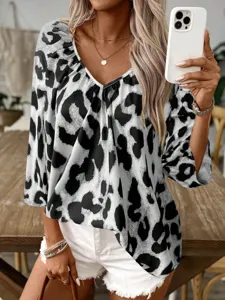 Detailed view of a stylish black and white leopard print V-neck women's blouse top.