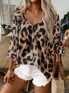 Detailed view of a fashionable leopard print V-neck blouse in a stylish indoor setting.