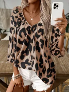 Close-up detail shot of a stylish women's leopard print V-neck blouse worn by model.