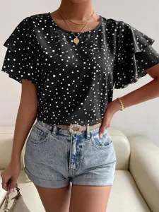 Detailed close-up of the black and white polka dot ruffle short sleeve blouse with denim shorts.