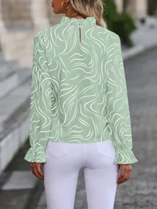 Back view of a light green long sleeve blouse featuring a ruffle high neck and abstract print.