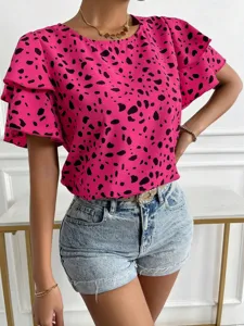 Pink short sleeve blouse detail showcasing abstract spot print and layered sleeve design.